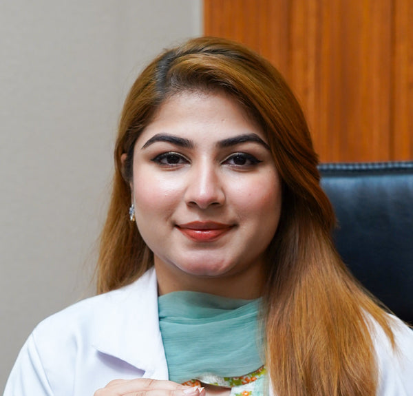 Woman in a white coat holding a bottle in an office setting